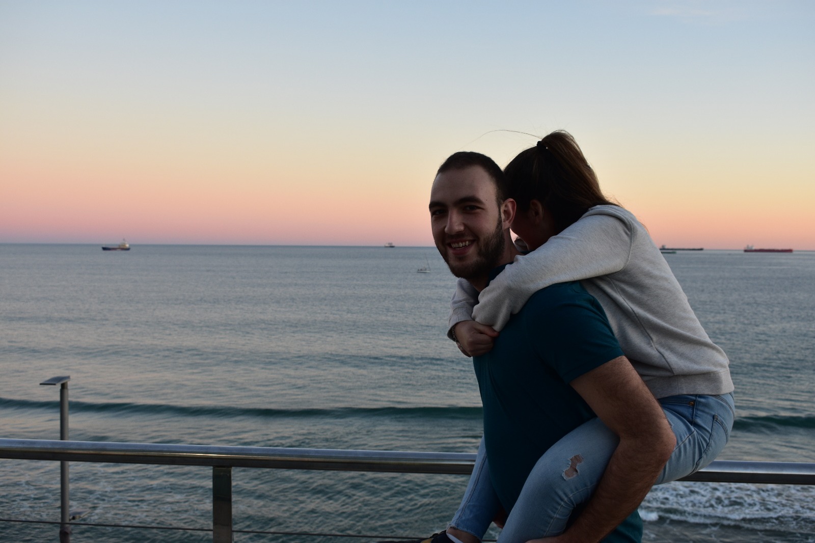 La pareja frente al mar al atardecer